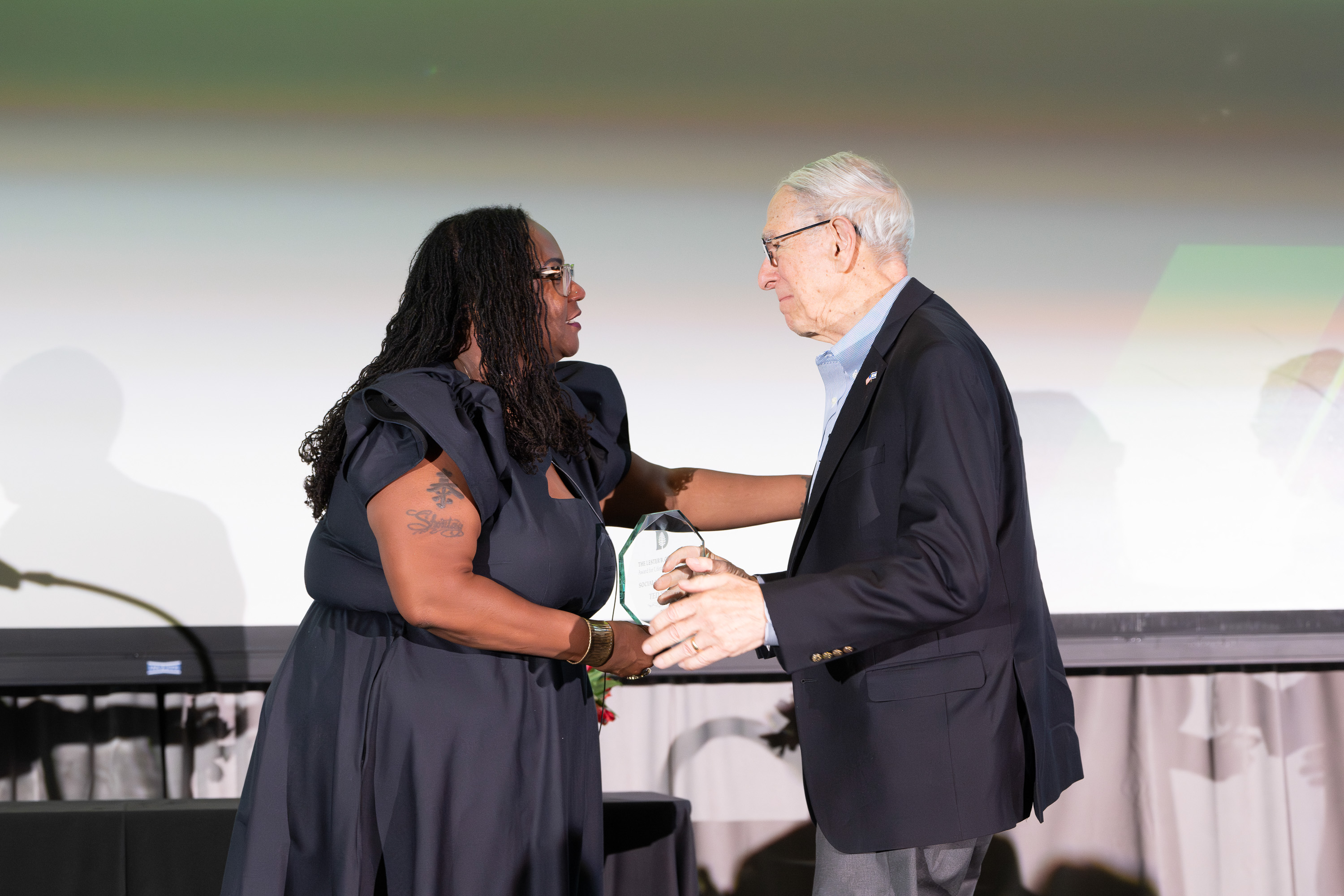 Theodore Tapper accepting an award from Shontay Delalue
